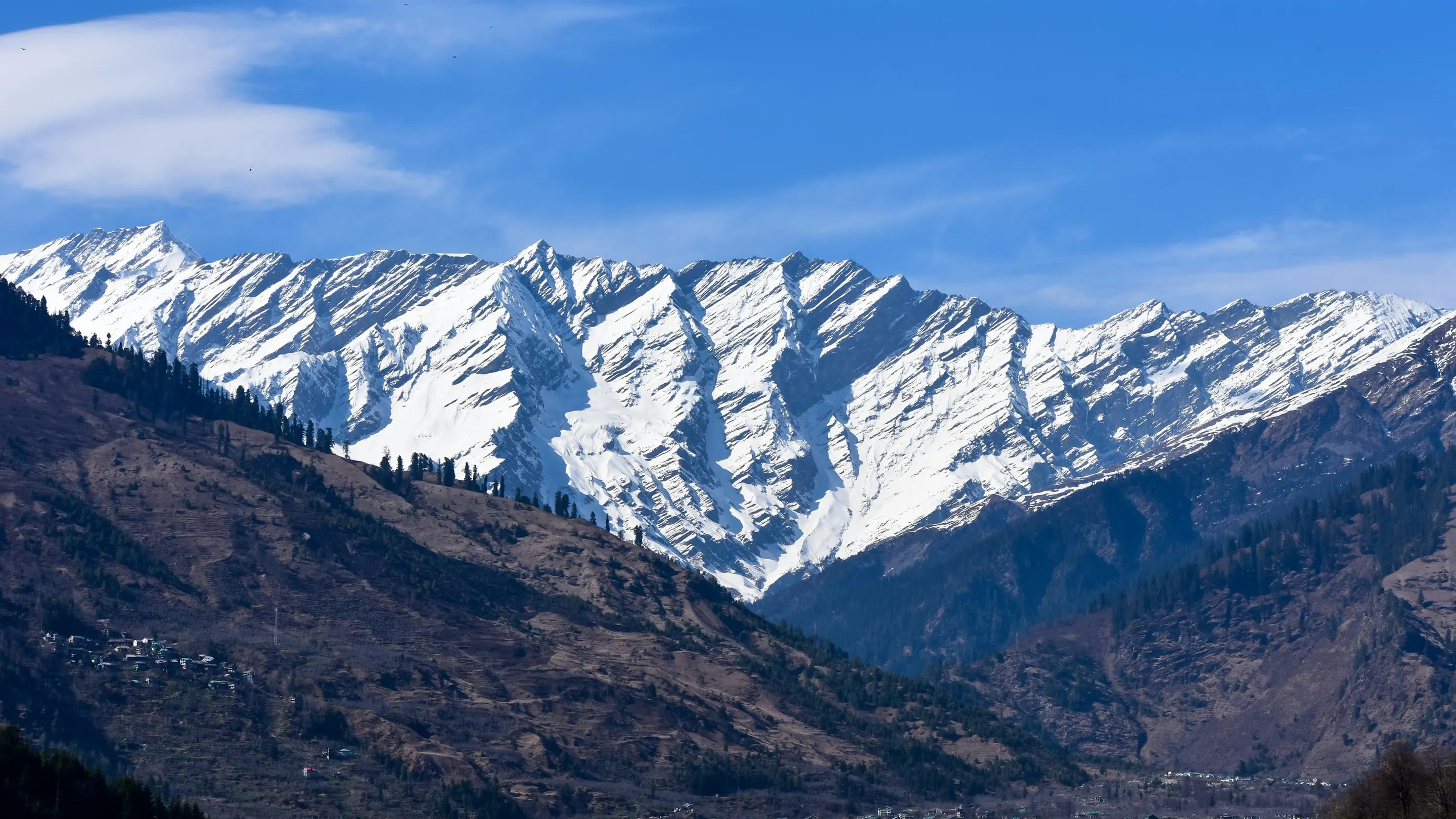 Snow-covered peaks above a forested valley near Solang, Himachal Pradesh