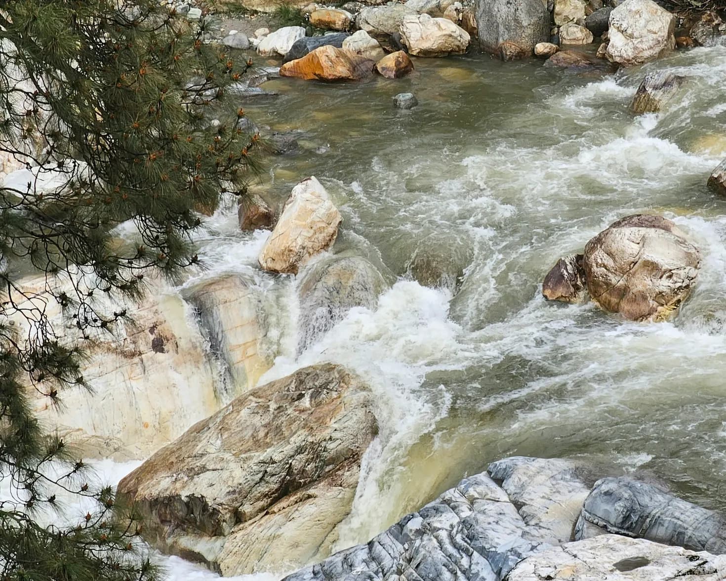 Water rushing between boulders in the Tirthan River