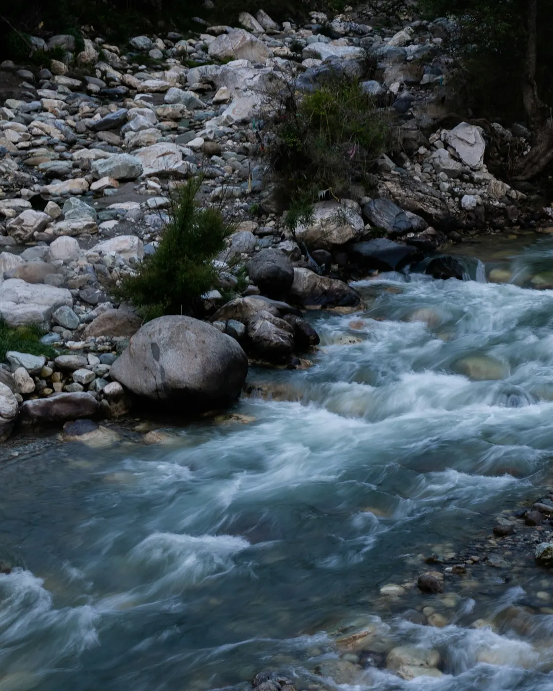 The Tirthan River flowing over rocks in Tirthan Valley