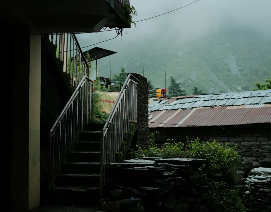 Stairs beside a hillside house in morning mist